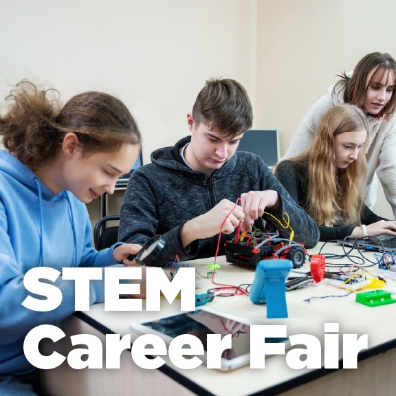 Students building a robot with circuits at a STEM Career Fair, hands-on learning at a children's science center.